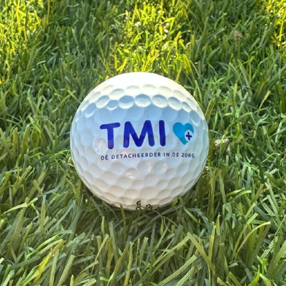 Bedrukte Titleist golfbal met TMI-logo in het gras
