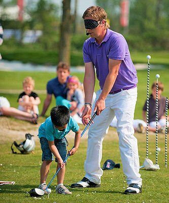 Mark Reynolds geeft een golfclinic aan kinderen op de driving range